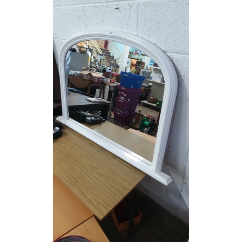 386 - White arched wall over mantle mirror with a wooden frame.