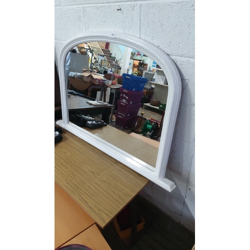 386 - White arched wall over mantle mirror with a wooden frame.