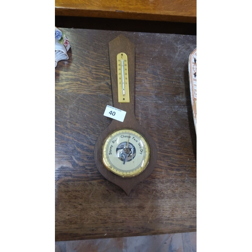 40 - Wooden barometer with attached thermometer, featuring a brass bezel and German manufacture stamp.