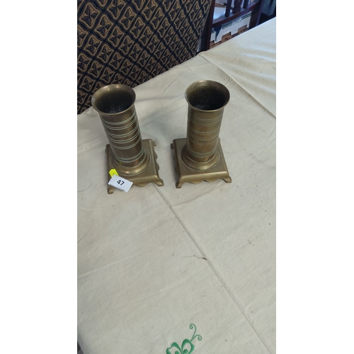 47 - Pair of brass cylindrical candle holders with fluted design on square bases.