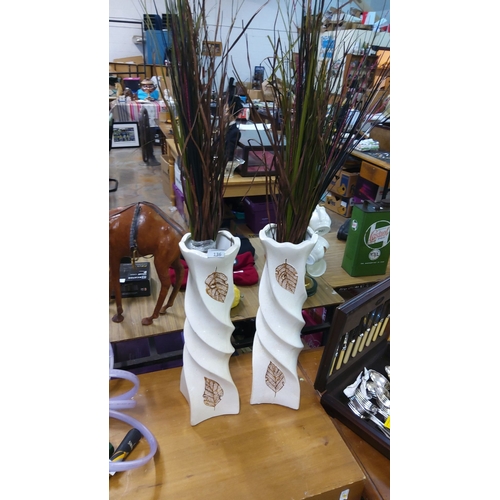 136 - Pair of white ceramic vases with spiral design and leaf motif decoration.