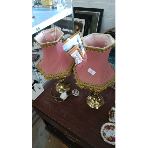 165 - Pair of brass table lamps with pink pleated fabric shades, adorned with gold trim and tassels.