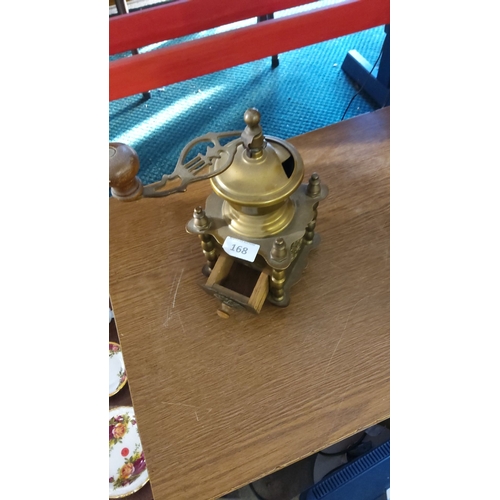 168 - Antique brass and wood coffee grinder with a hand crank and small drawer. Features ornamental metalw... 