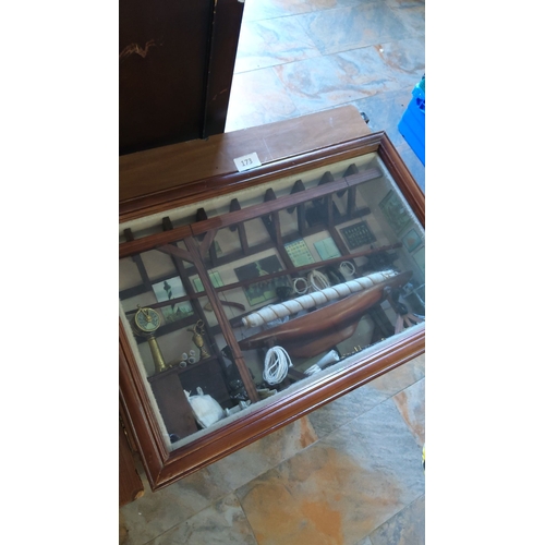 173 - Wooden-framed shadow box showcases a maritime diorama, featuring detailed nautical instruments, coil... 