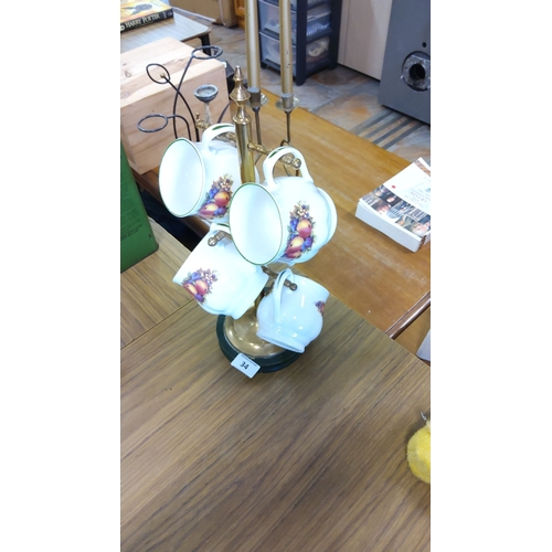 34 - Set of six porcelain mugs with fruit design, complemented by a brass stand.