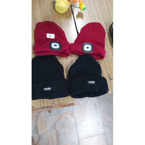 35 - Set of four knitted beanies, two red with integrated LED lights and two black labeled 