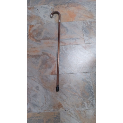 41 - Vintage wooden walking cane with silver band & tip,features a classic curved design.