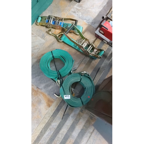 473 - Two green ratchet tie-down straps with metal hooks and buckles.