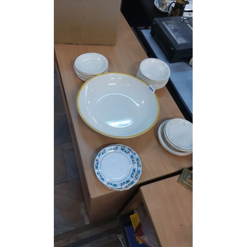 489 - Mixed lot of ceramic dishes, including white saucers, a large bowl with a yellow rim, and a floral p... 