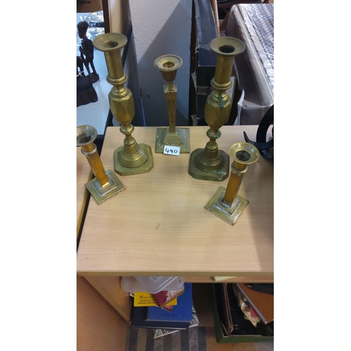 490 - Set of five brass candlesticks in varying heights and designs.