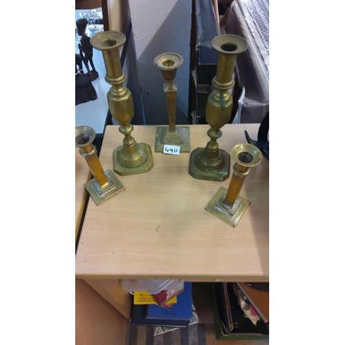 490 - Set of five brass candlesticks in varying heights and designs.