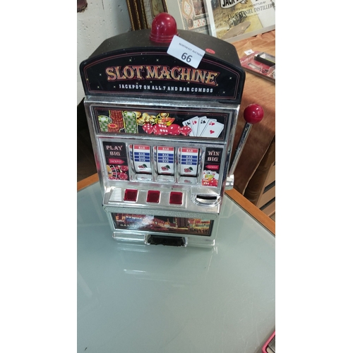 66 - Tabletop slot machine,with lever arm and traditional fruit symbols. Decorative graphics feature the ... 