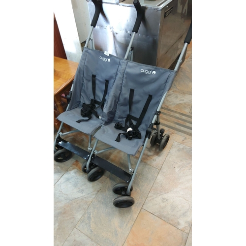 77 - Double stroller with grey fabric seats and black harnesses, featuring locking wheels and ergonomic h... 