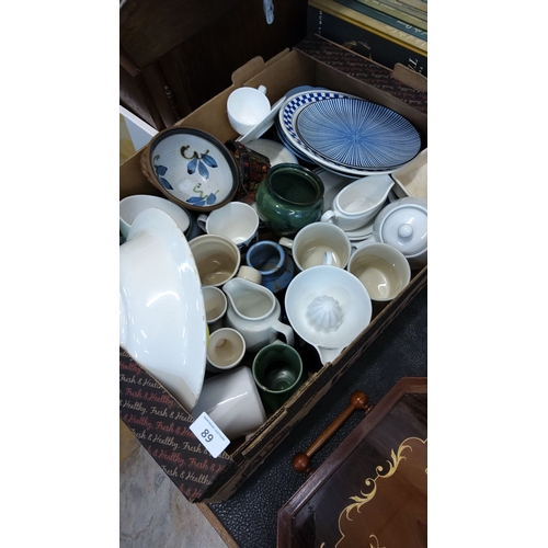 89 - Mixed lot of ceramic kitchenware includes plates, bowls, cups, pitchers, and a citrus juicer. Assort... 