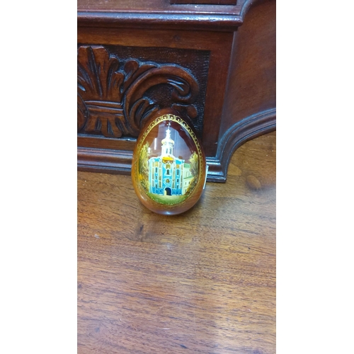 103 - Hand-painted wooden egg with intricate architectural scene, featuring a central domed building.