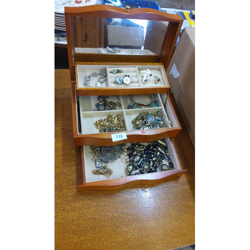 116 - Wooden box containing assorted jewelry items such as rings, bracelets, and necklaces. Features mixed... 