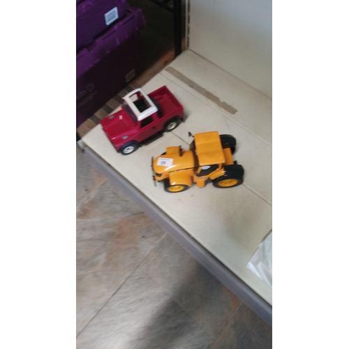 29 - Set of two toy vehicles: red truck with white roof and yellow tractor. Plastic construction, vibrant... 
