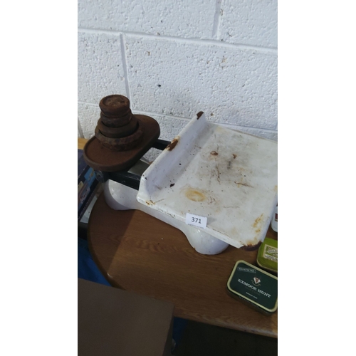 371 - Vintage cast iron balance scale with rusted weights. Approximately 30cm wide, 25cm deep, 20cm high.