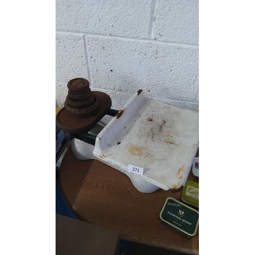 371 - Vintage cast iron balance scale with rusted weights. Approximately 30cm wide, 25cm deep, 20cm high.