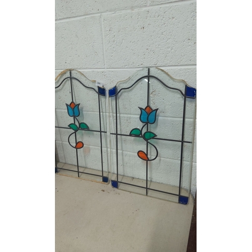 388 - Pair of stained glass panels with floral motif, featuring blue, teal, and orange accents. Approximat... 