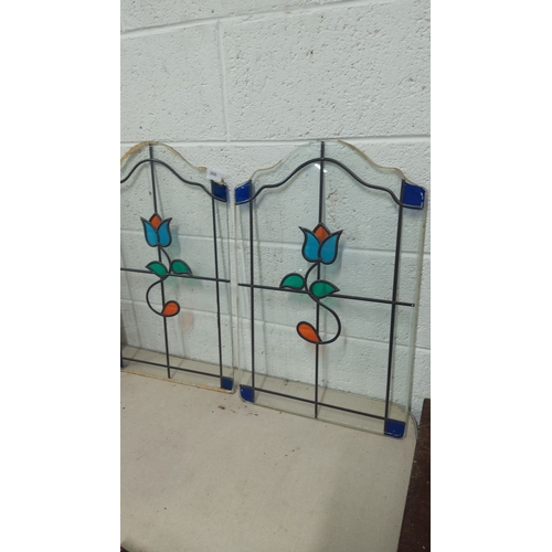 388 - Pair of stained glass panels with floral motif, featuring blue, teal, and orange accents. Approximat... 
