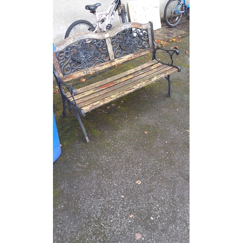 405 - Outdoor bench with ornate cast iron sides featuring floral design backrest. Approximately 120cm long... 