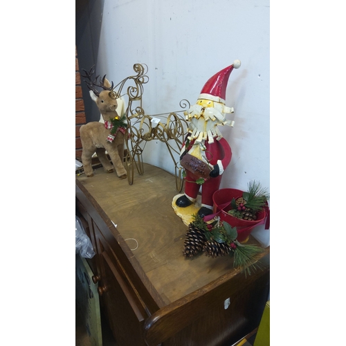 80 - Metal Santa figure, plush reindeer, and decorative sleigh.