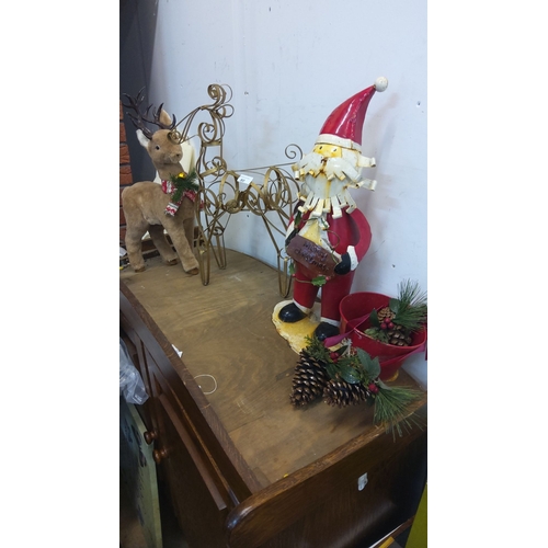80 - Metal Santa figure, plush reindeer, and decorative sleigh.