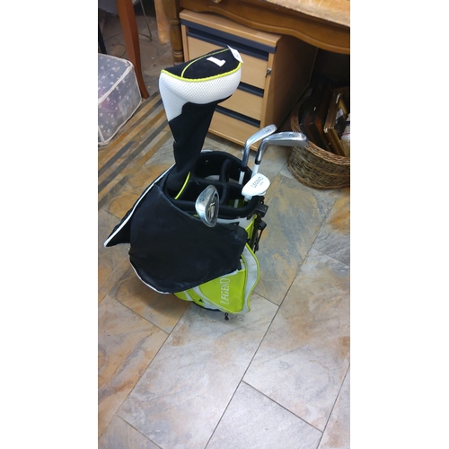 82 - Junior Golf bag in vibrant green and black design, including assorted clubs with club covers.