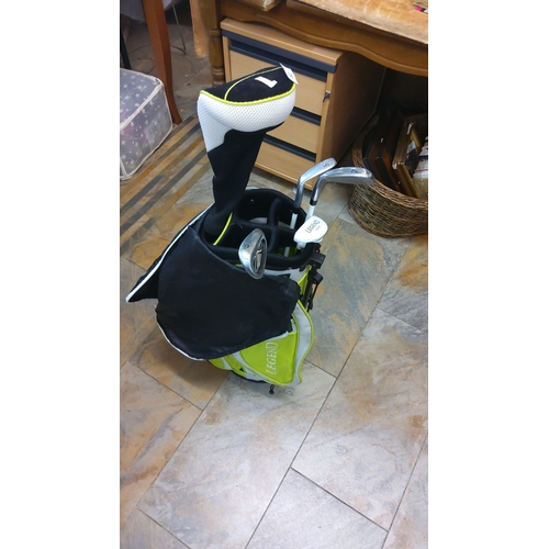 82 - Junior Golf bag in vibrant green and black design, including assorted clubs with club covers.