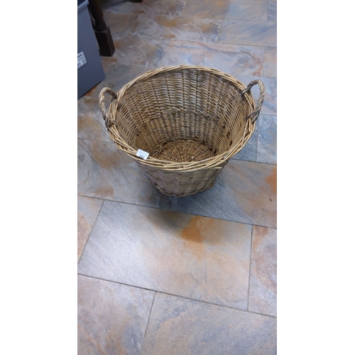 265 - Woven fireside willow basket with twin handles, approximately 60 cm in diameter and 40 cm in height.