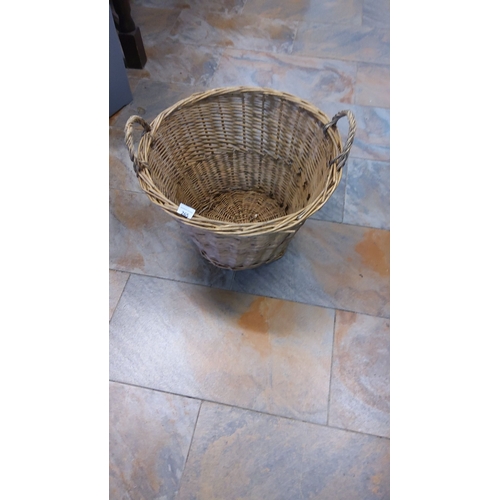 265 - Woven fireside willow basket with twin handles, approximately 60 cm in diameter and 40 cm in height.