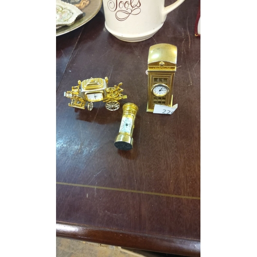 226 - Three miniature carriage clocks in gold-tone metal, featuring ornate designs. Includes a carriage, p... 