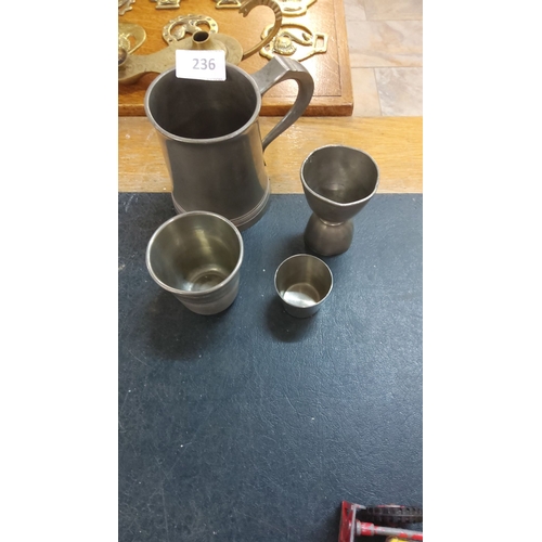 236 - Set of four pewter drinking measures, including a handled tankard and various cups. Simple yet elega... 