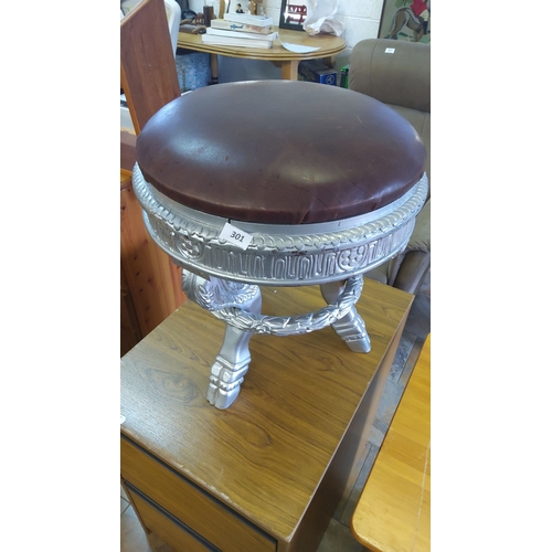 301 - Silver-painted stool with ornate carvings and a brown leather seat cushion. Includes intricately des... 