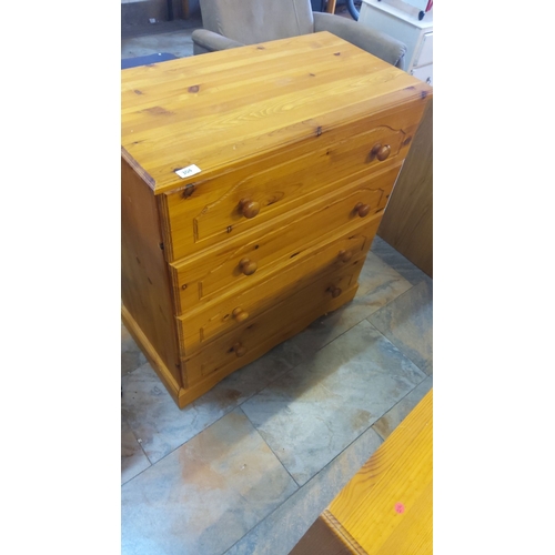 304 - Pine chest of drawers featuring four drawers with round wooden knobs.