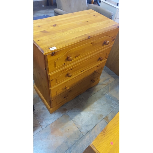 304 - Pine chest of drawers featuring four drawers with round wooden knobs.