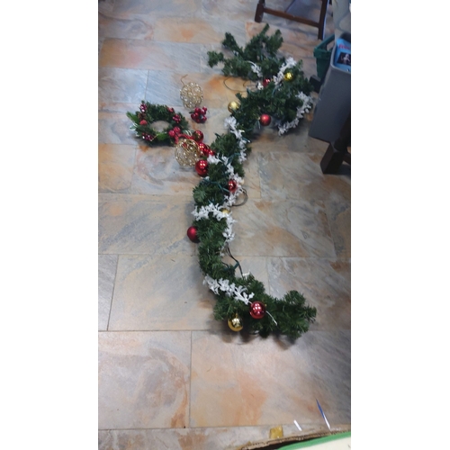 312 - Decorative Christmas garland features green foliage, red and gold ornaments, and white accents,light... 