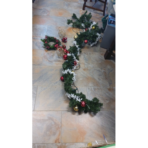 312 - Decorative Christmas garland features green foliage, red and gold ornaments, and white accents,light... 