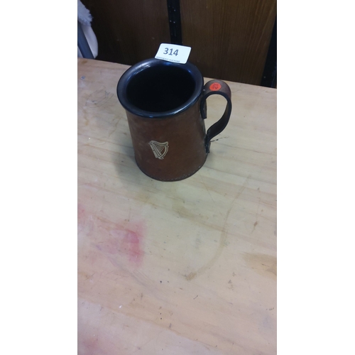 314 - Stoneware Guinness beer mug features a harp emblem, indicative of a traditional design.
