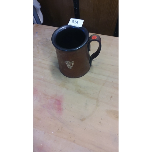314 - Stoneware Guinness beer mug features a harp emblem, indicative of a traditional design.