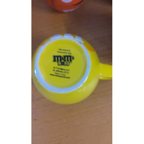 321 - Set of four colorful M&M's World ceramic mugs featuring character faces