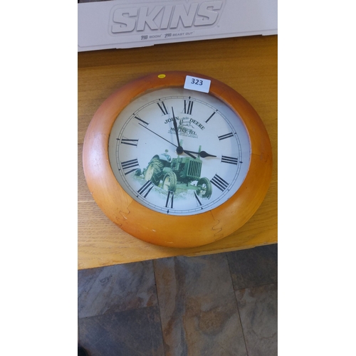 323 - Round wall clock featuring a John Deere tractor design, wood frame, Roman numerals.