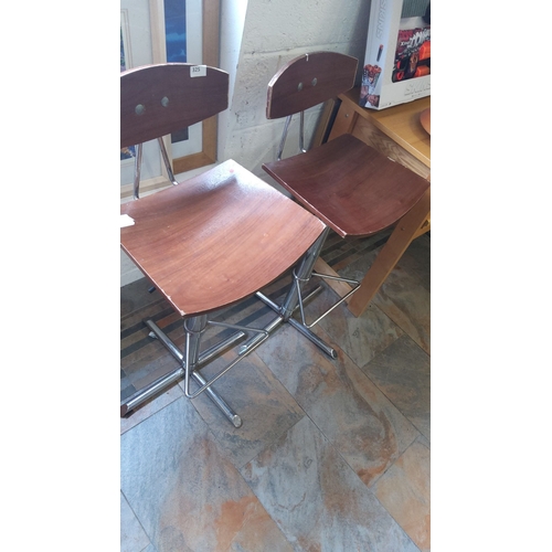325 - Pair of mid-century modern stools with wooden seats and metal frames.