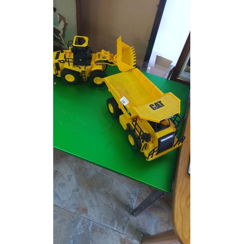338 - Two CAT construction toy vehicles, including a dump truck and front loader, in bright yellow plastic... 