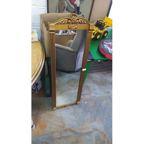 343 - Gold-framed mirror with ornate top detailing, featuring fluted sides.