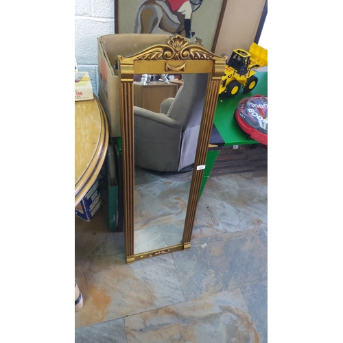 343 - Gold-framed mirror with ornate top detailing, featuring fluted sides.