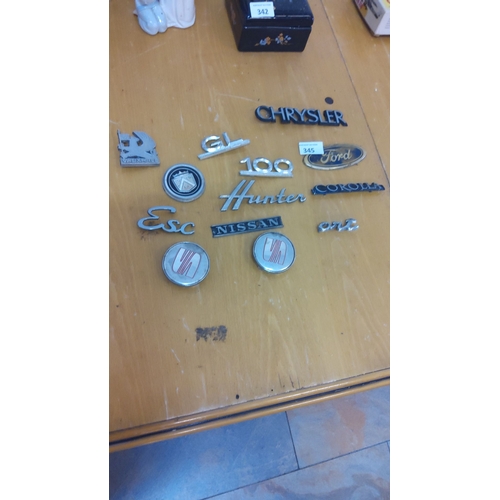 345 - Collection of vintage car badges and emblems, featuring brands like Chrysler, Ford, Nissan, Vauxhall... 
