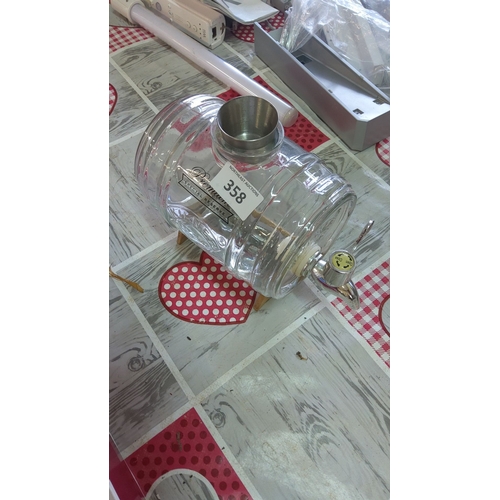 358 - Glass barrel decanter with wooden stand and shot measure,featuring a metal spout and 