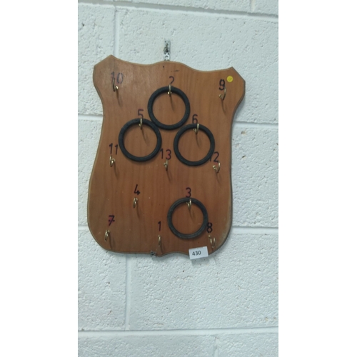 430 - Vintage wooden ring toss game board with numbered hooks and rubber rings.